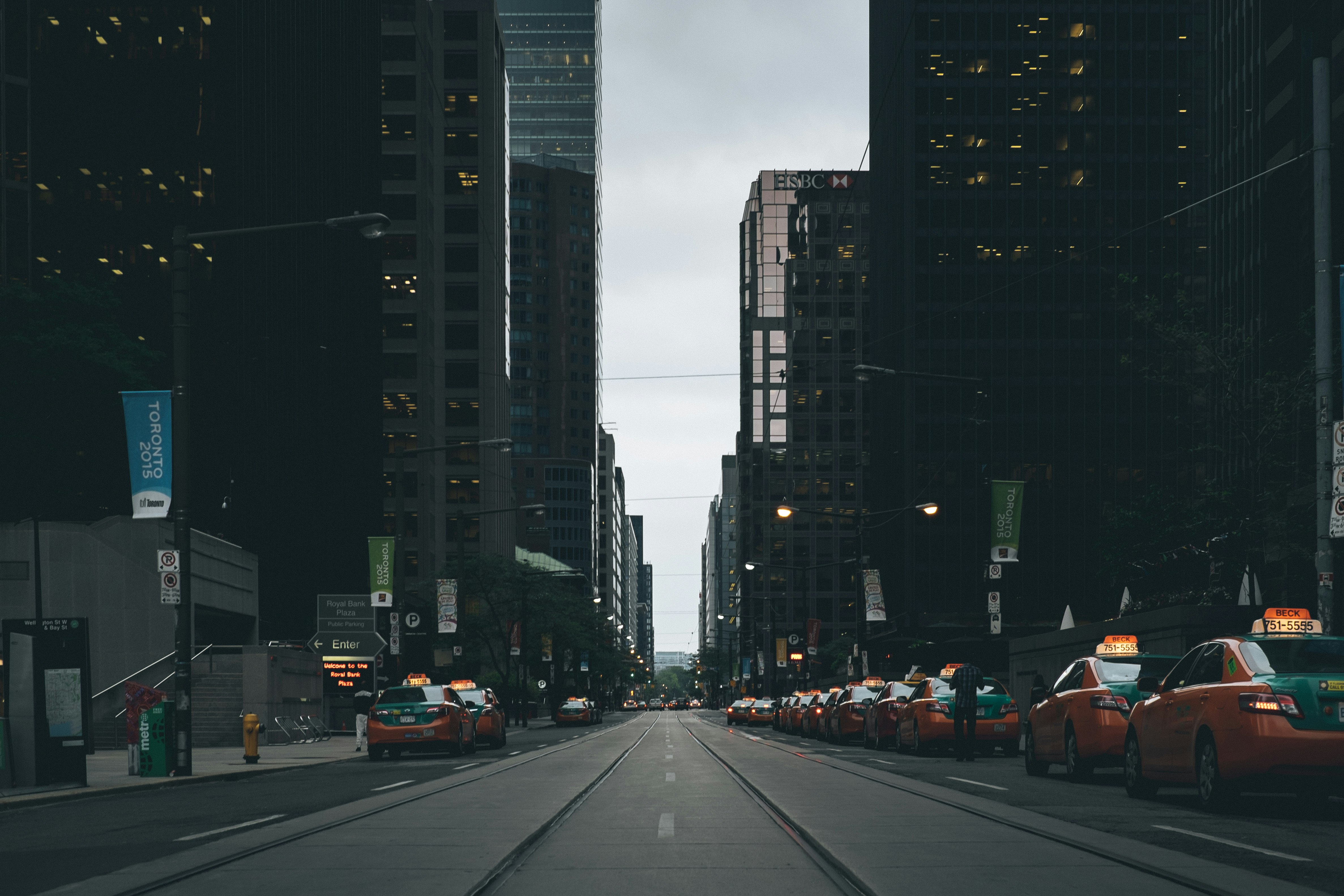 photo of orange cabs parked on pavement near buildings